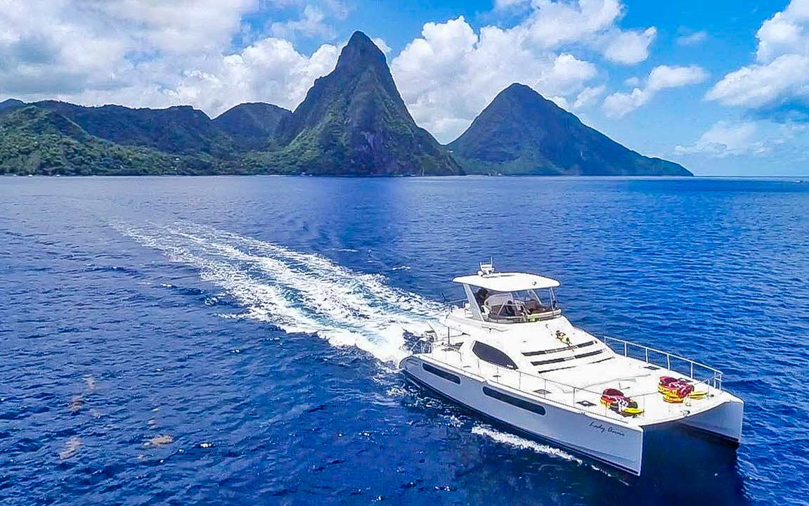 Luxury yacht sailing on the Caribbean Sea with Gros Piton and Petit Piton rising in the background in Saint Lucia