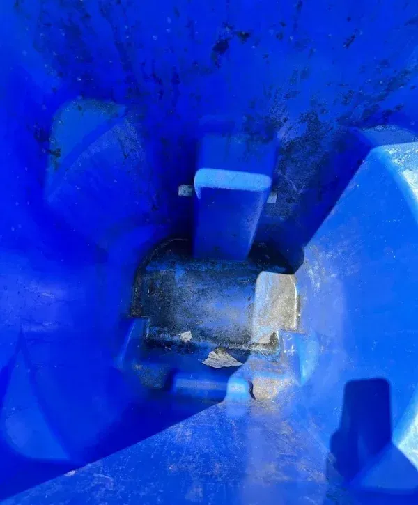 Dirty blue trash bin interior before professional cleaning showing grime and debris