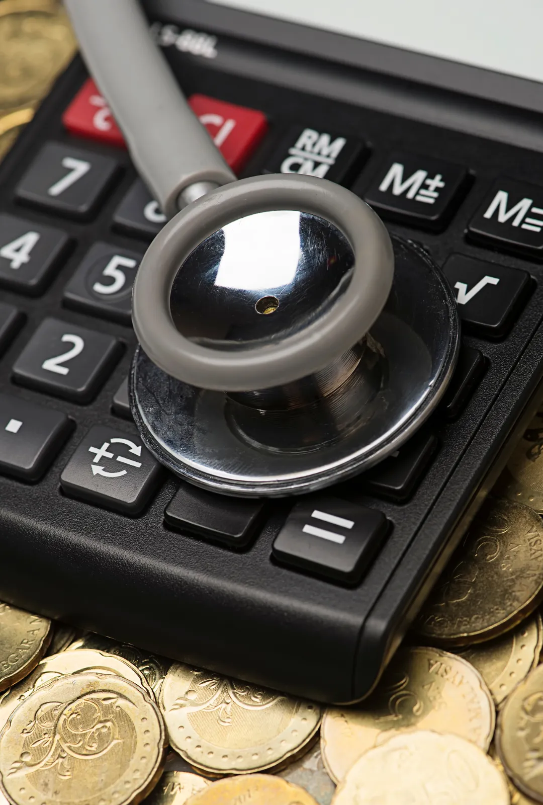Estetoscopio sobre una calculadora financiera, simbolizando diagnóstico económico y revisión estructural