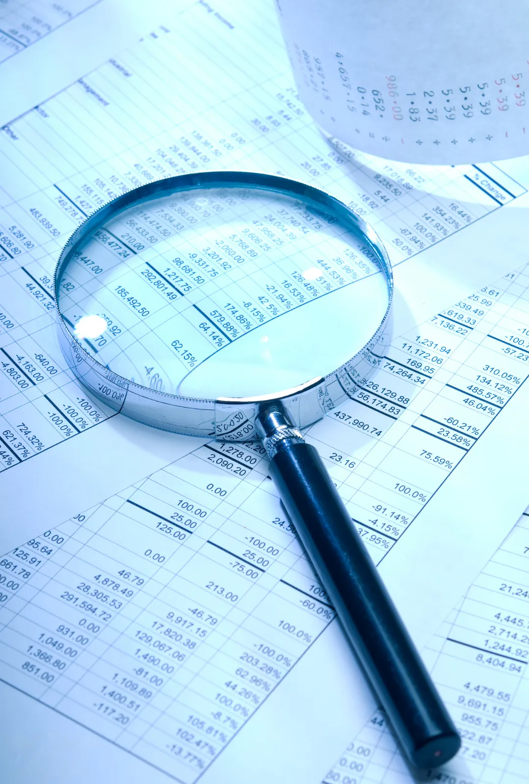 Lupa sobre informe financiero como símbolo de análisis detallado y asesoría estratégica personalizada