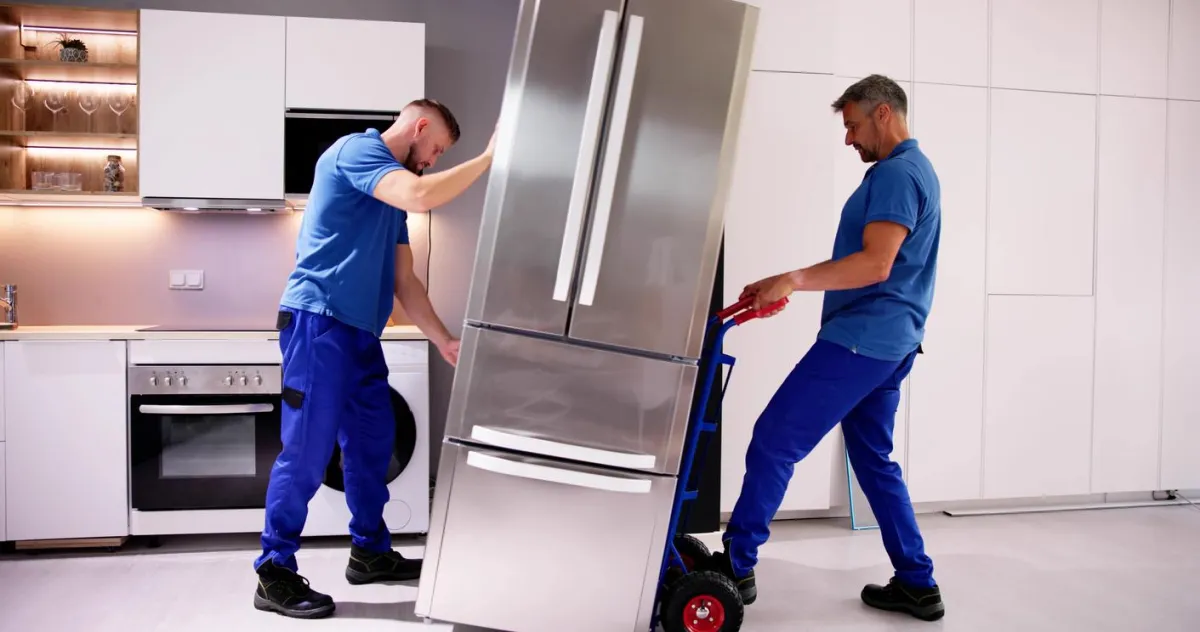 two technician move fridge in kitchen