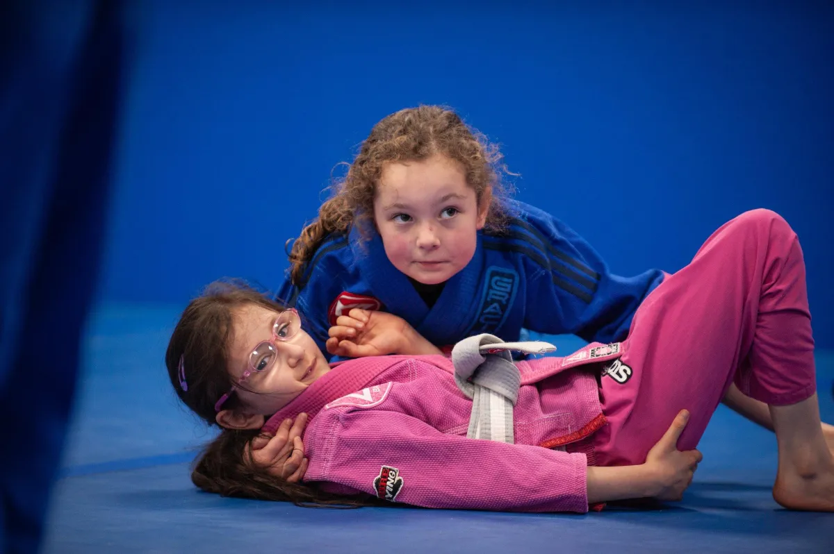 kids grappling and listening to teacher