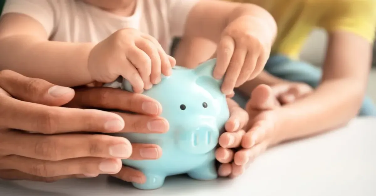Családi kezek egy kék malacpersely körül – közös megtakarítás gyermek jövőjére és családi pénzügyi biztonságra.