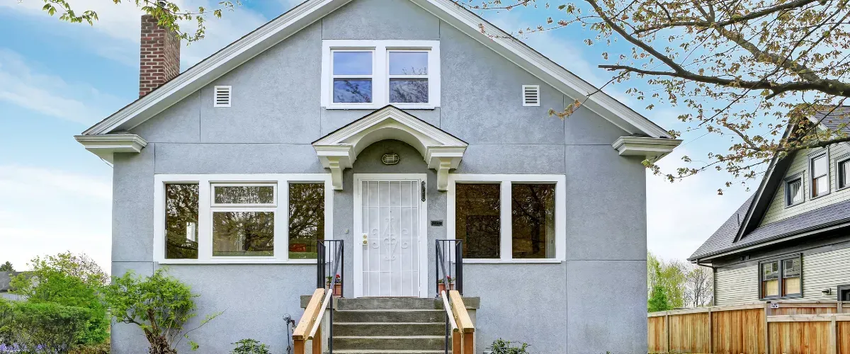 Straight-on view of a gray residential home with white trim and small front steps