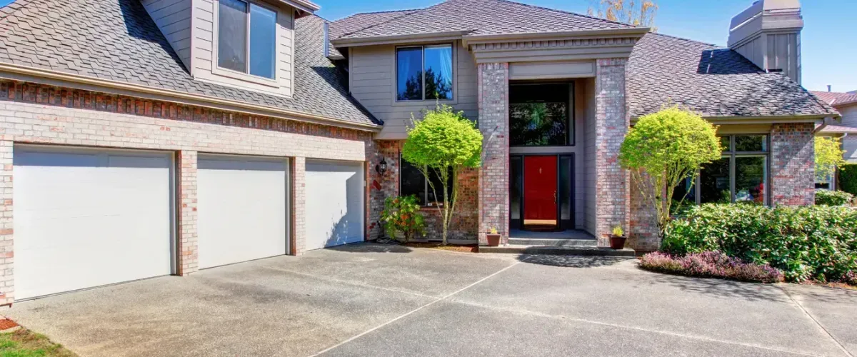 Modern brick home with a spacious three-car garage and well-maintained driveway