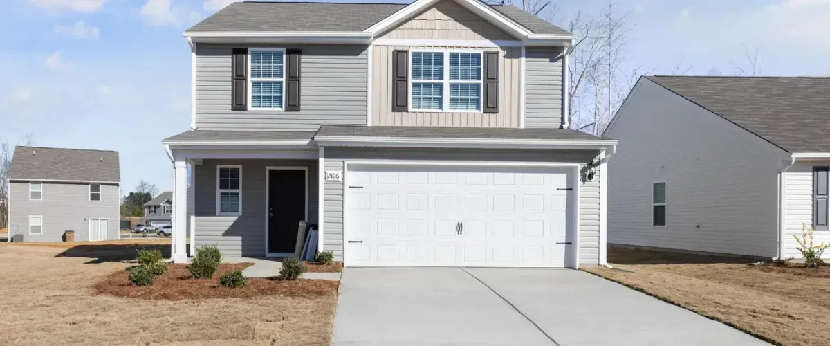 Clean concrete driveway in front of a modern suburban house.