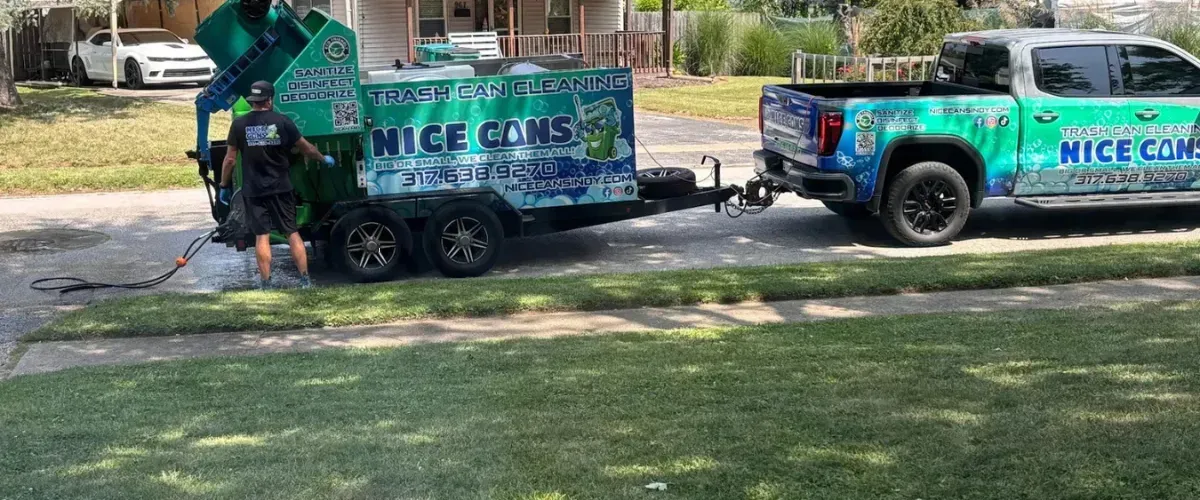 Professional trash can cleaning service truck parked on site with technician sanitizing outdoor bins