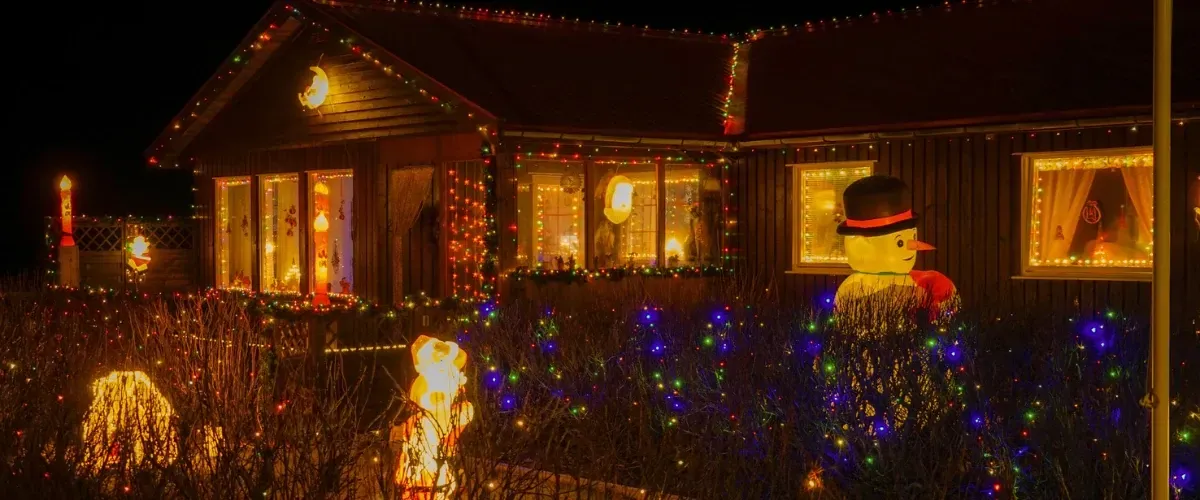 House decorated with colorful Christmas lights and glowing holiday figures in Speedway, Indiana.