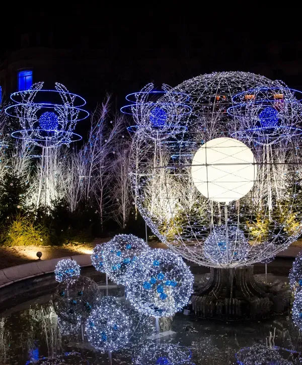 Outdoor holiday light sculpture display featuring glowing spheres and decorative installations.