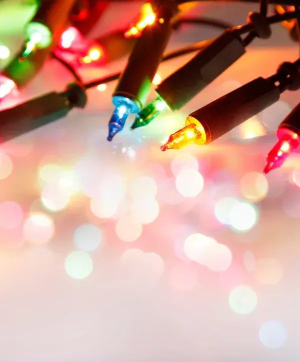 Colorful close-up of multicolored Christmas string lights with festive bokeh