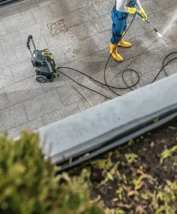 Commercial pressure washing service cleaning a concrete sidewalk with professional equipment.