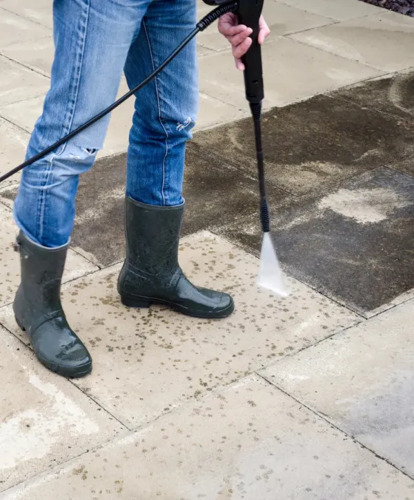 Pressure washing concrete pavers to remove stains, moss, and surface grime