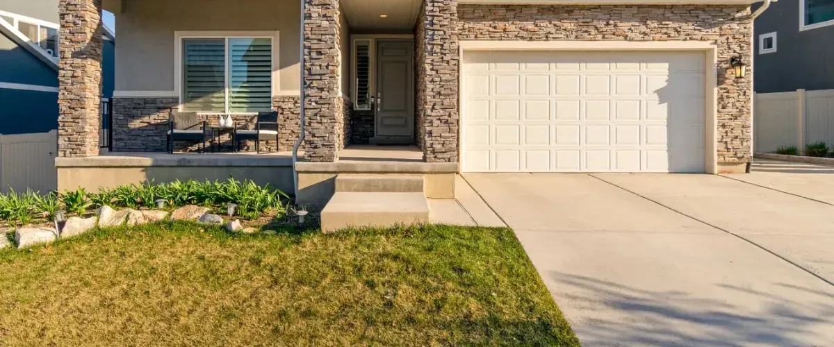 Residential home exterior with a driveway cleaned after professional pressure washing.
