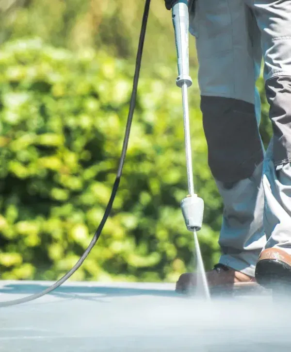 Close-up of pressure washing patio pavers with high-pressure spray