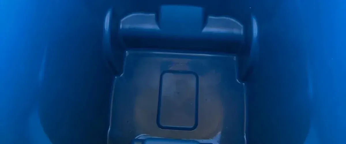 A close-up, high-angle view looking down into the dark blue interior of a plastic bin or container.