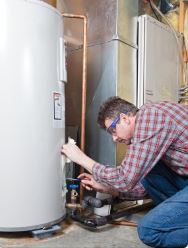Technician performing water heater maintenance for Woodburn HVAC