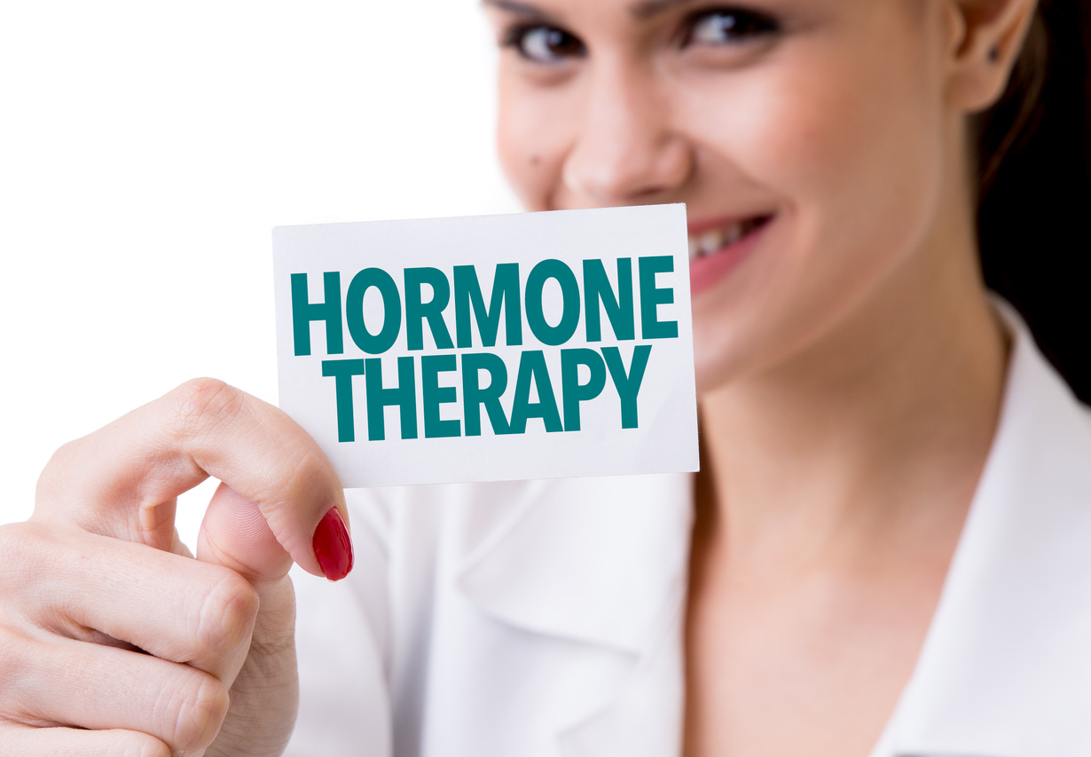 Woman holding sign with Hormone Therapy text, bioidentical hormone replacement therapy.