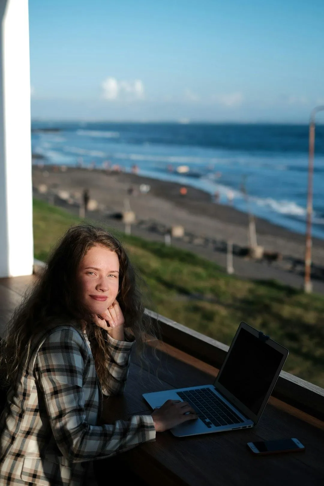 woman smiling to the camera while on her computer