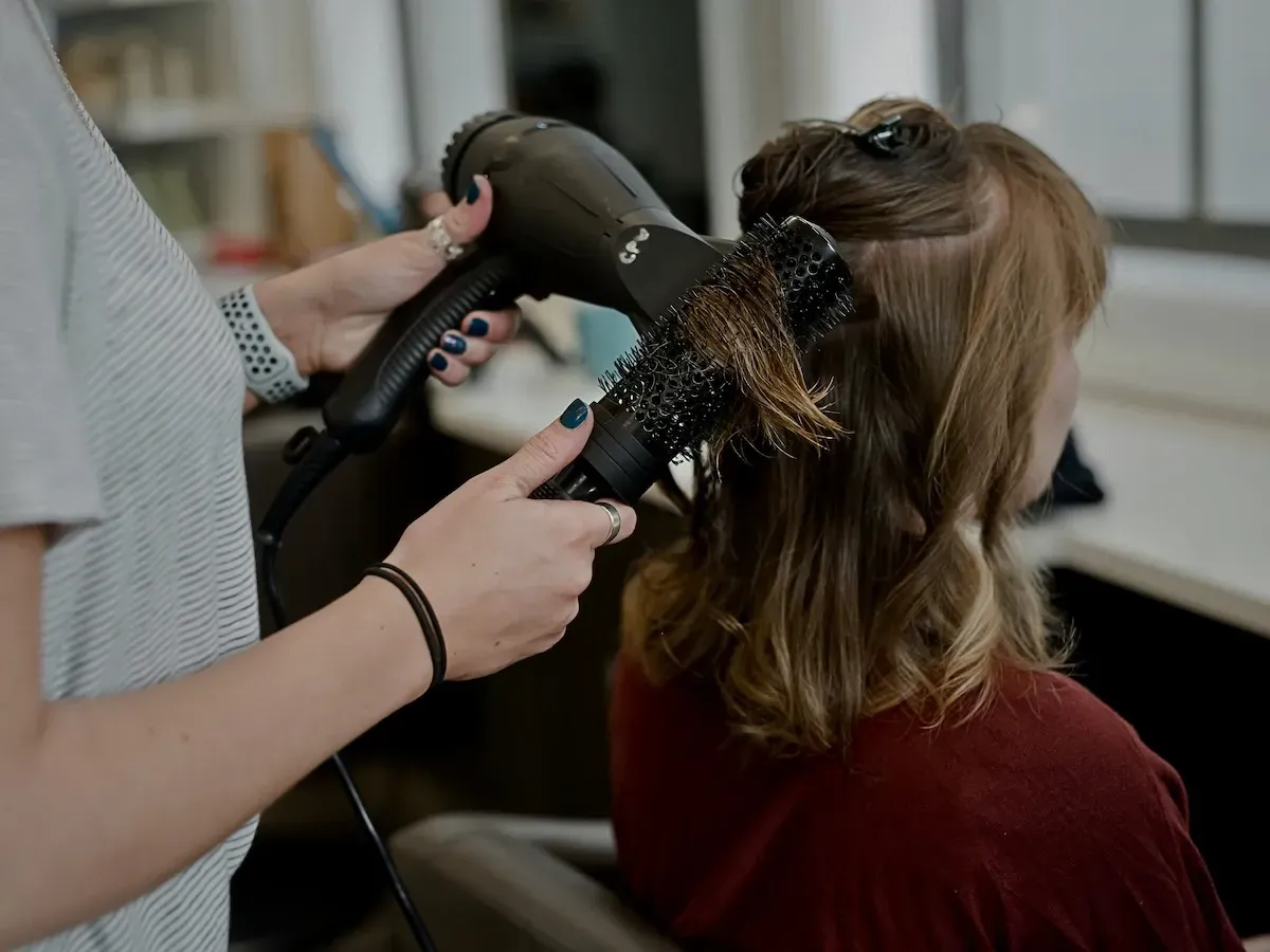 Kingston hairstylist blow-drying client in modern salon