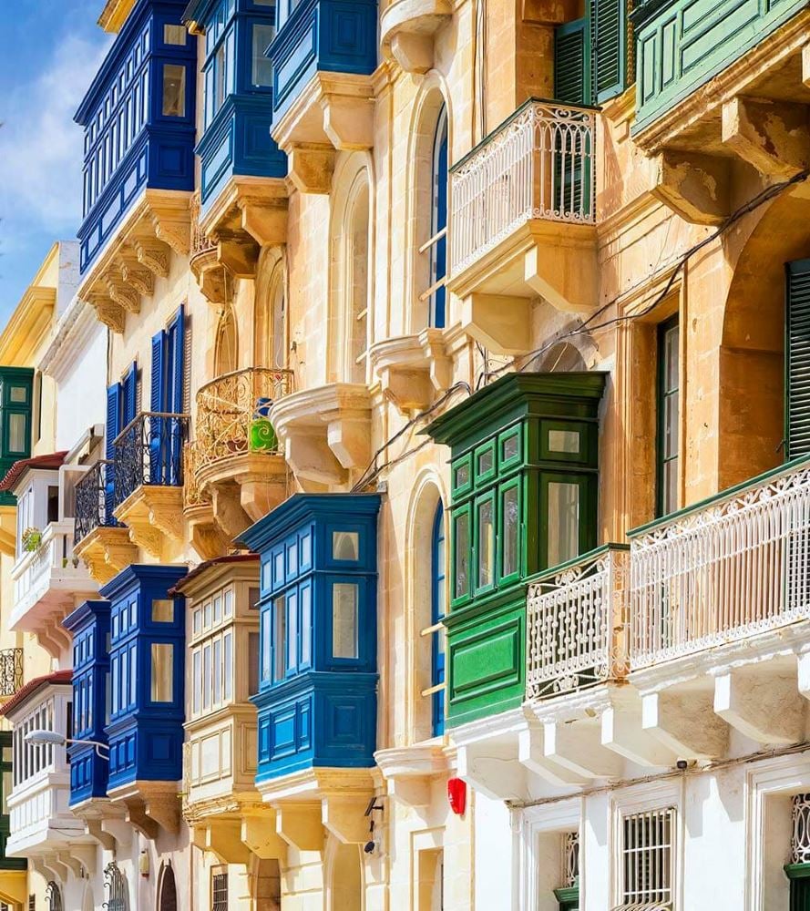 An old building with green shutters on a street corner