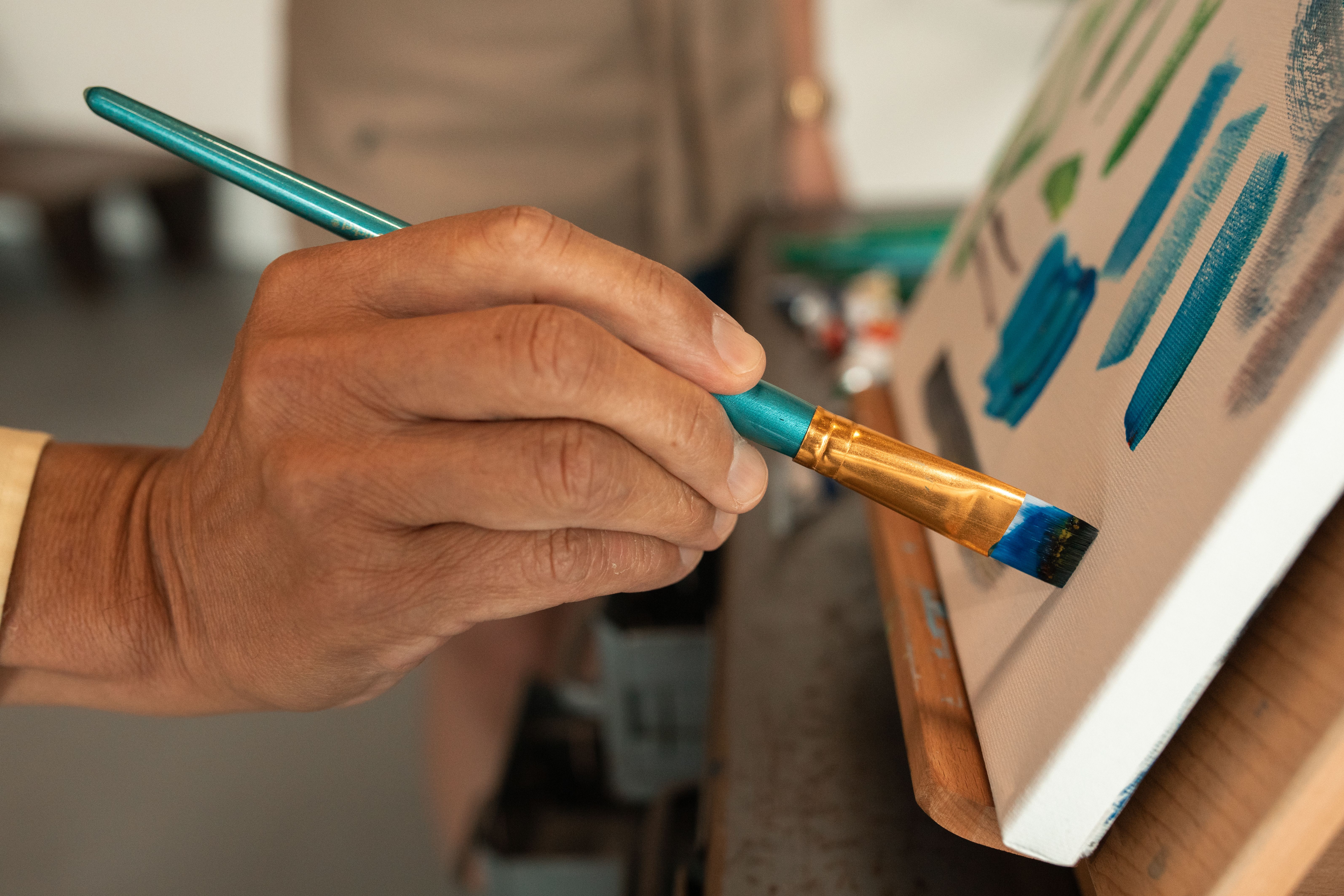 Art class in a bright studio with students painting at easels