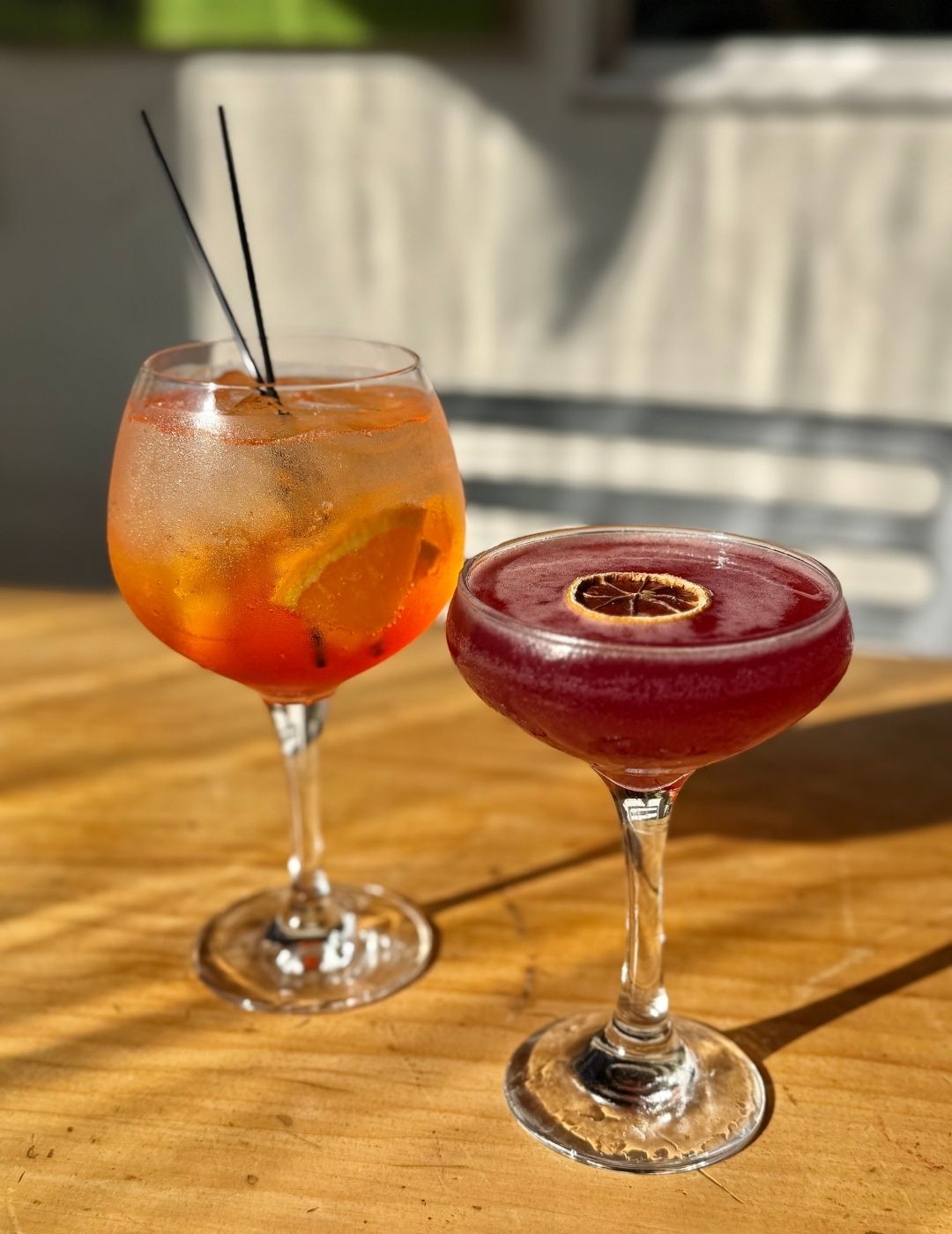A colorful Aperol Spritz-style cocktail with an orange slice and ice
