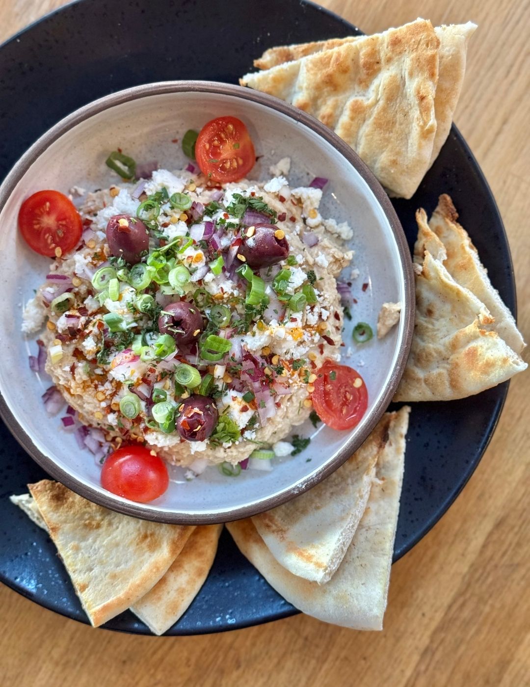 A vibrant mezze or grain bowl with mixed toppings and sauces