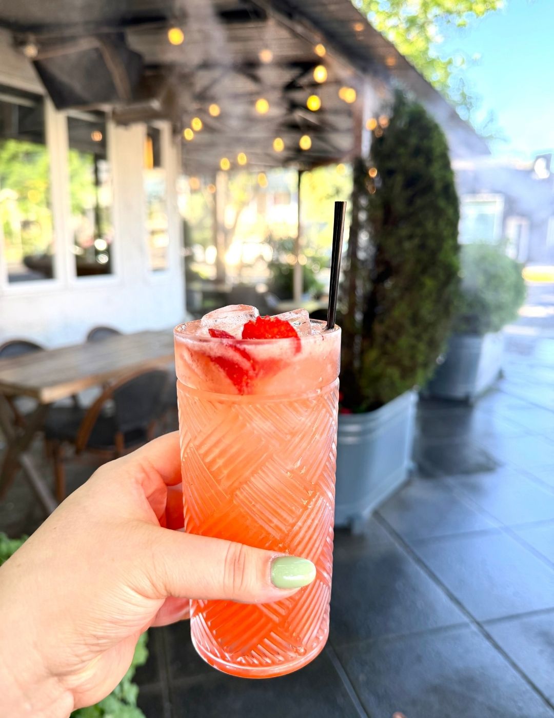 Rose-colored cocktail garnished with strawberry
