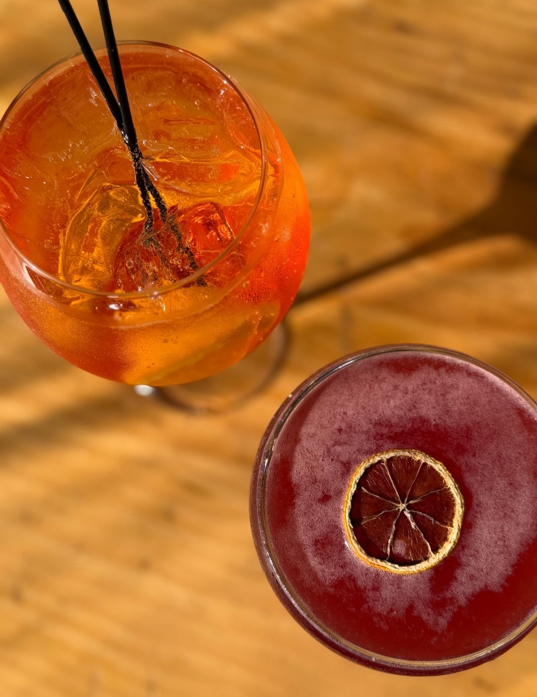 A dark red mocktail or cocktail in a short glass, viewed from above