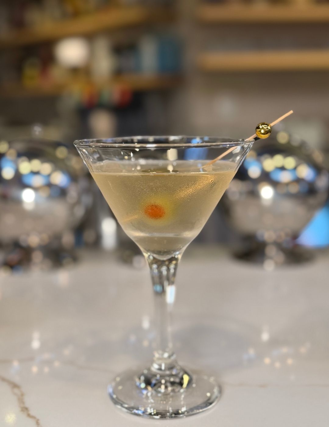 A classic martini in a chilled martini glass with an olive garnish