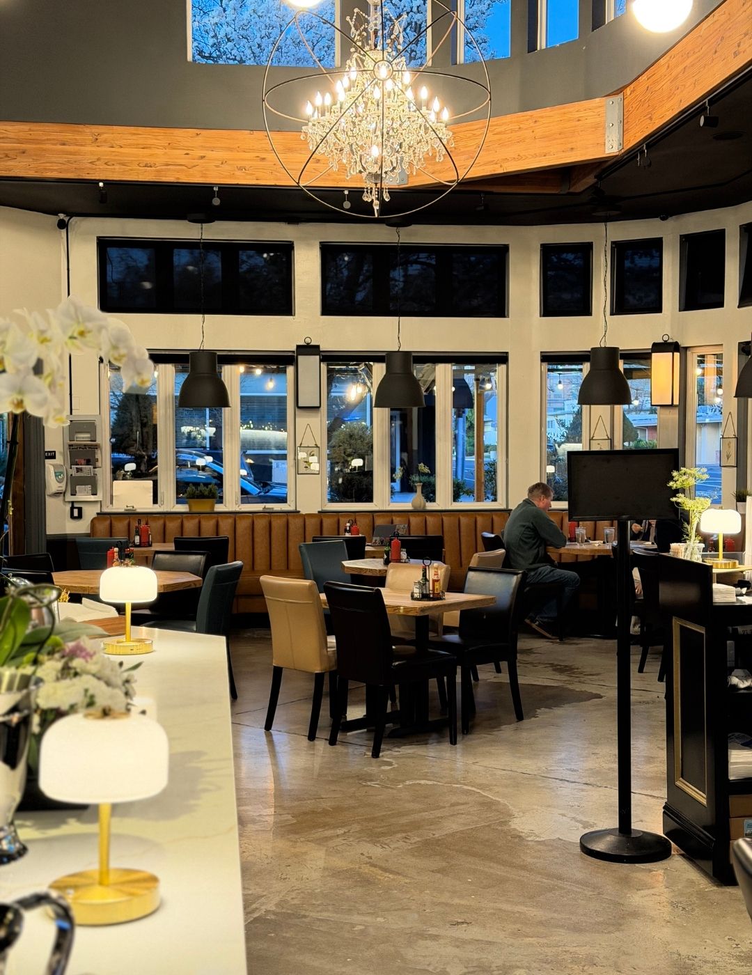 A bright and airy café interior with large windows and wooden furniture