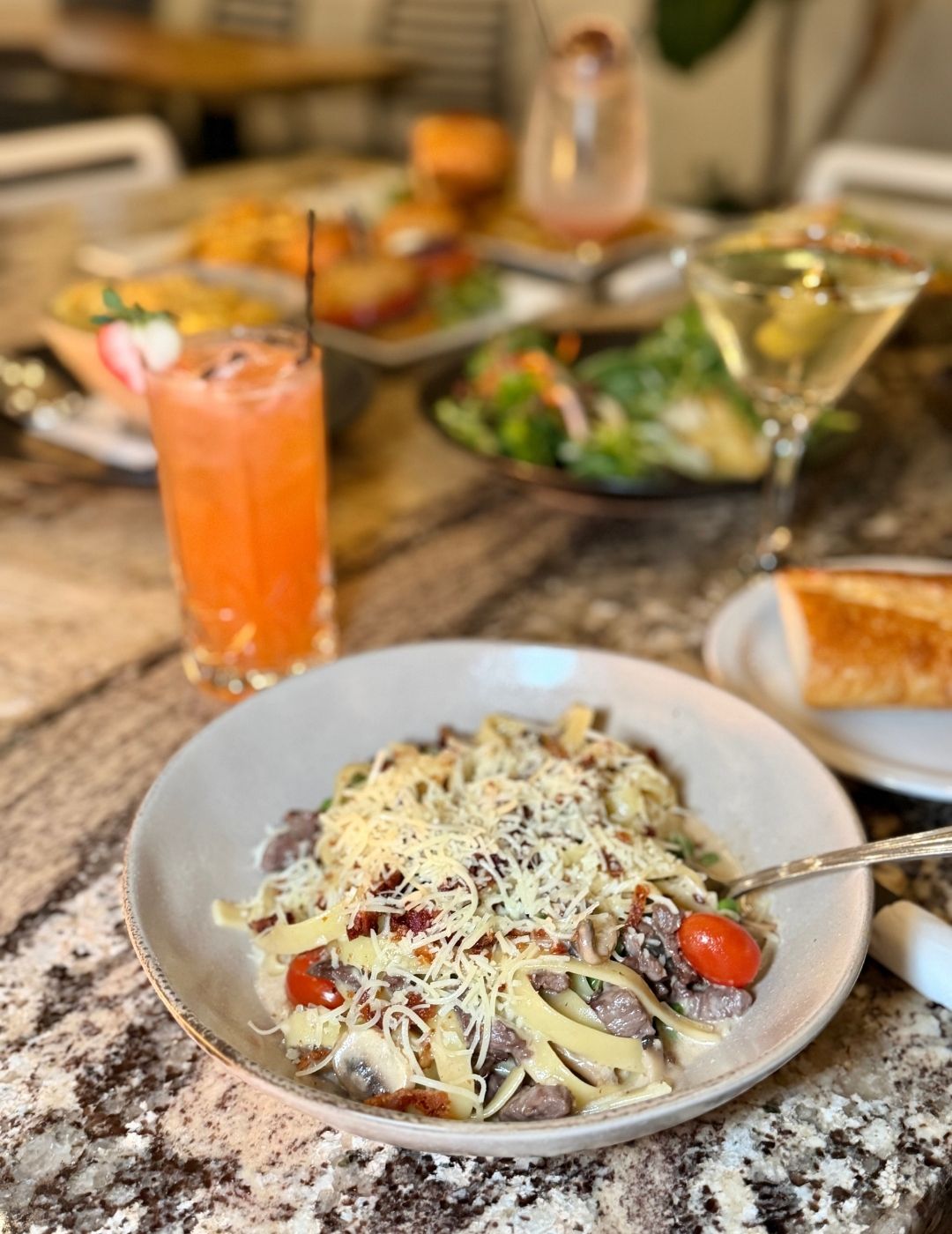 Pasta with orange cocktail on the side