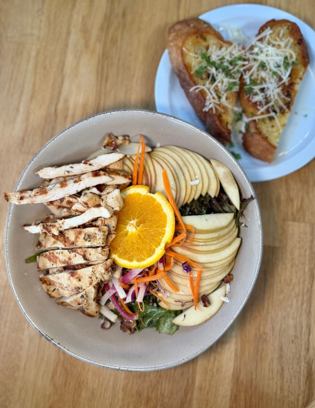 A grilled or seared protein served over a vegetable bowl