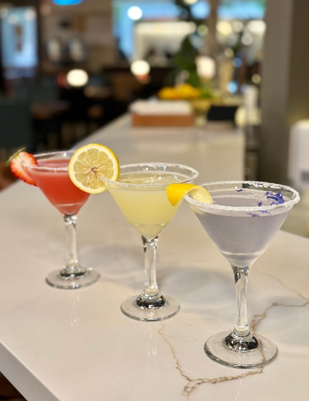 A dark cocktail in a short glass with ice, viewed from above on a wooden surface