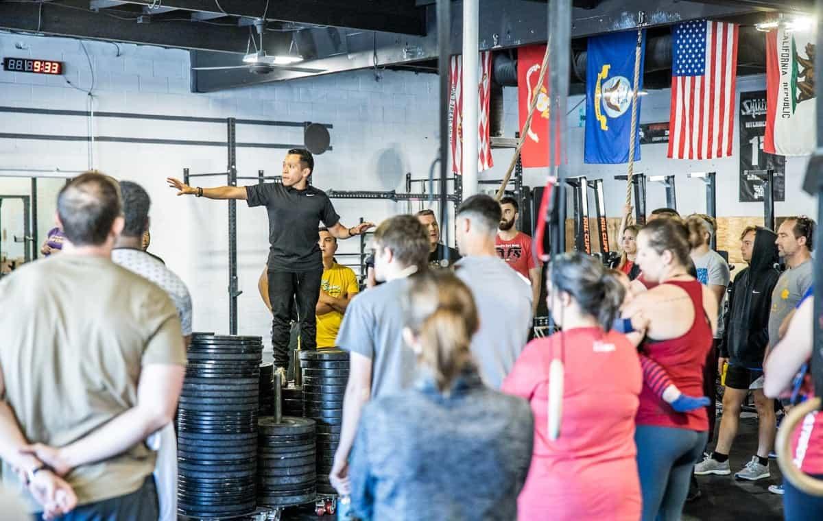 A coach briefing a full class at CrossFit Fortius