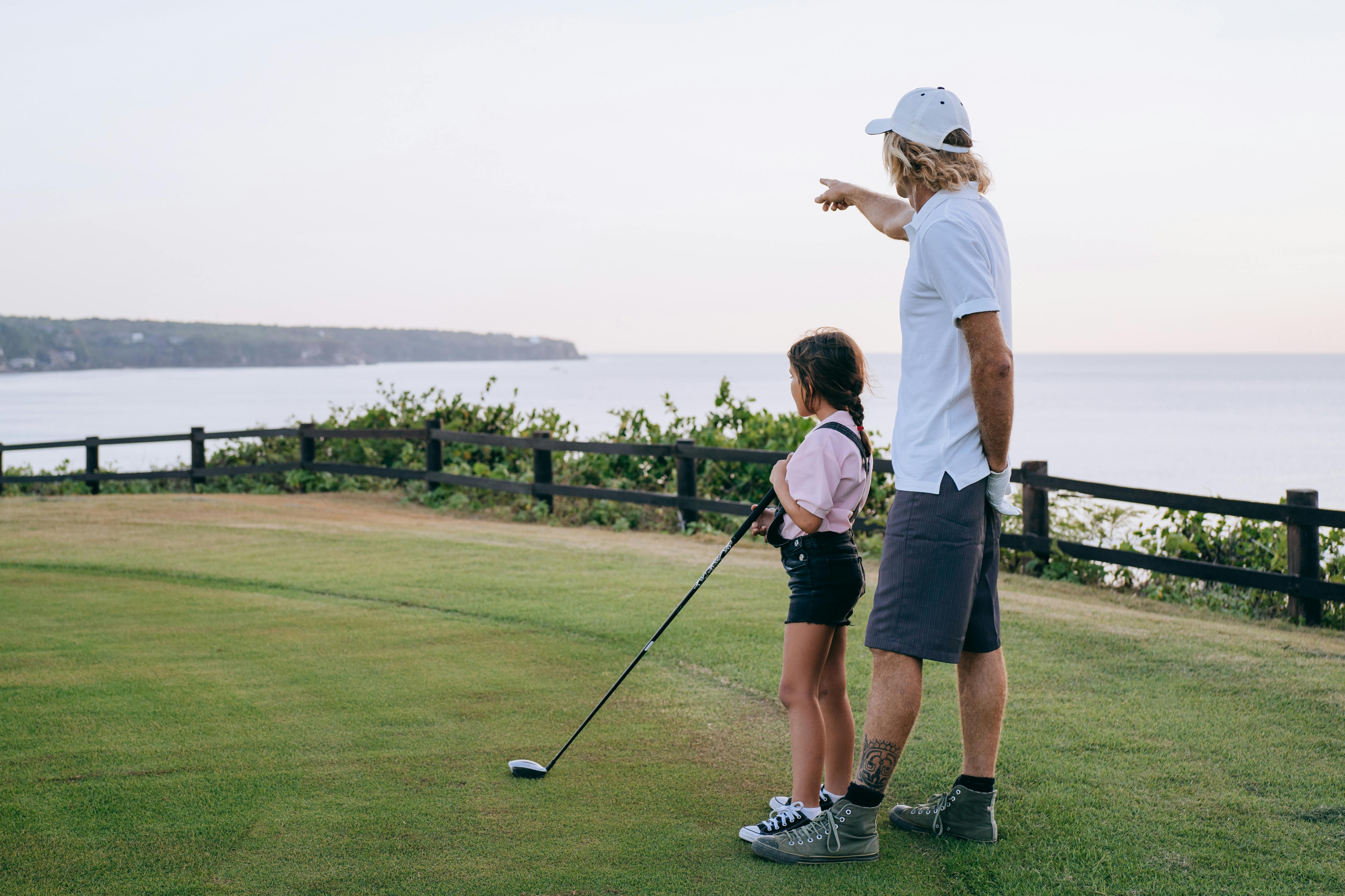 A golf coach instructing a child.