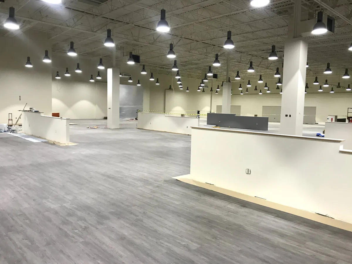 Large commercial showroom interior painting by DL Coatings: open warehouse drywall coatings, floor masking protection, and fast buildout turnaround.