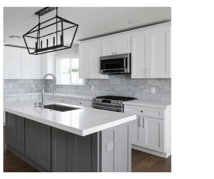 This kitchen blends contemporary design with classic comfort, featuring a two-toned color scheme that pairs chic gray base cabinets with pristine white upper cabinets. The elegant marble backsplash weaves in a touch of luxury, harmonizing with the sleek quartz countertops. Central to the space is a large island, ideal for meal prep and socializing. Overhead, a striking black geometric chandelier adds a modern industrial vibe, illuminating the space with a cozy ambiance. The room's design is a testament to modern functionality meeting timeless style, making it an appealing heart of any home.