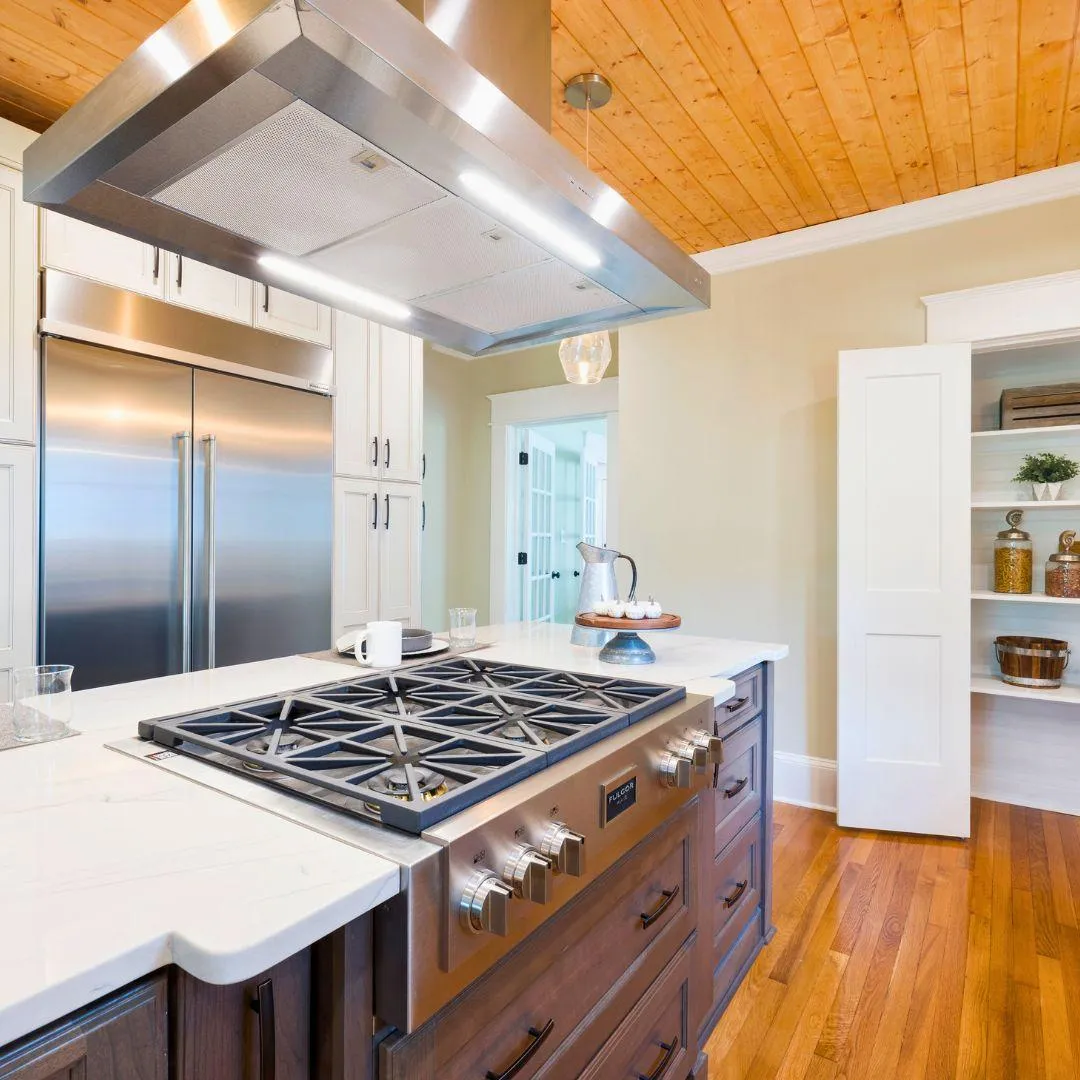 Rustic modern kitchen with stainless steel appliances, wood ceiling, large gas range, and custom cabinetry by Elci Cabinets and Floors.