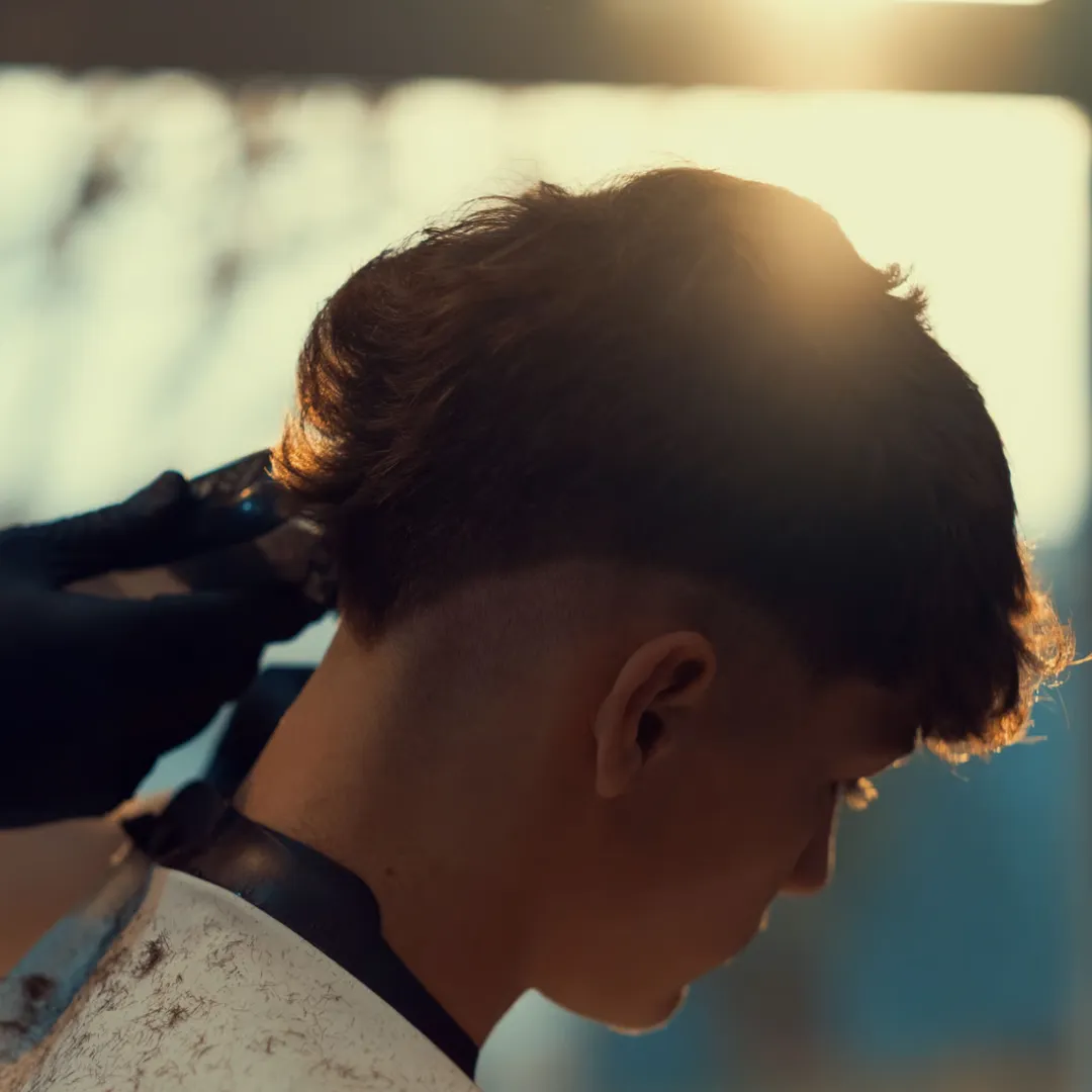 Man wearing a high skin fade with short thick hair on top