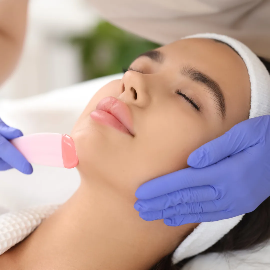 Female client undergoing chin hair removal with wax at a spa