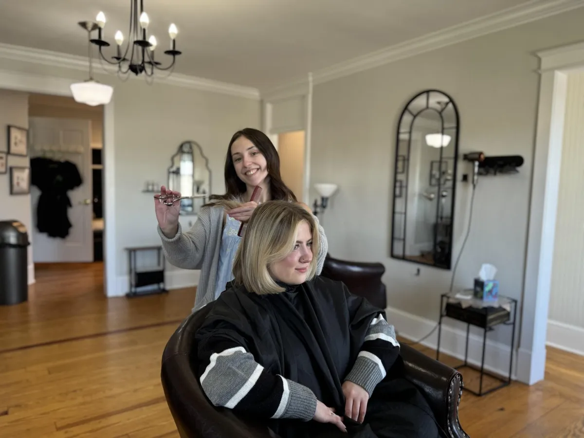 Zoe Zimmerman, owner, smiling at the salon with a customer