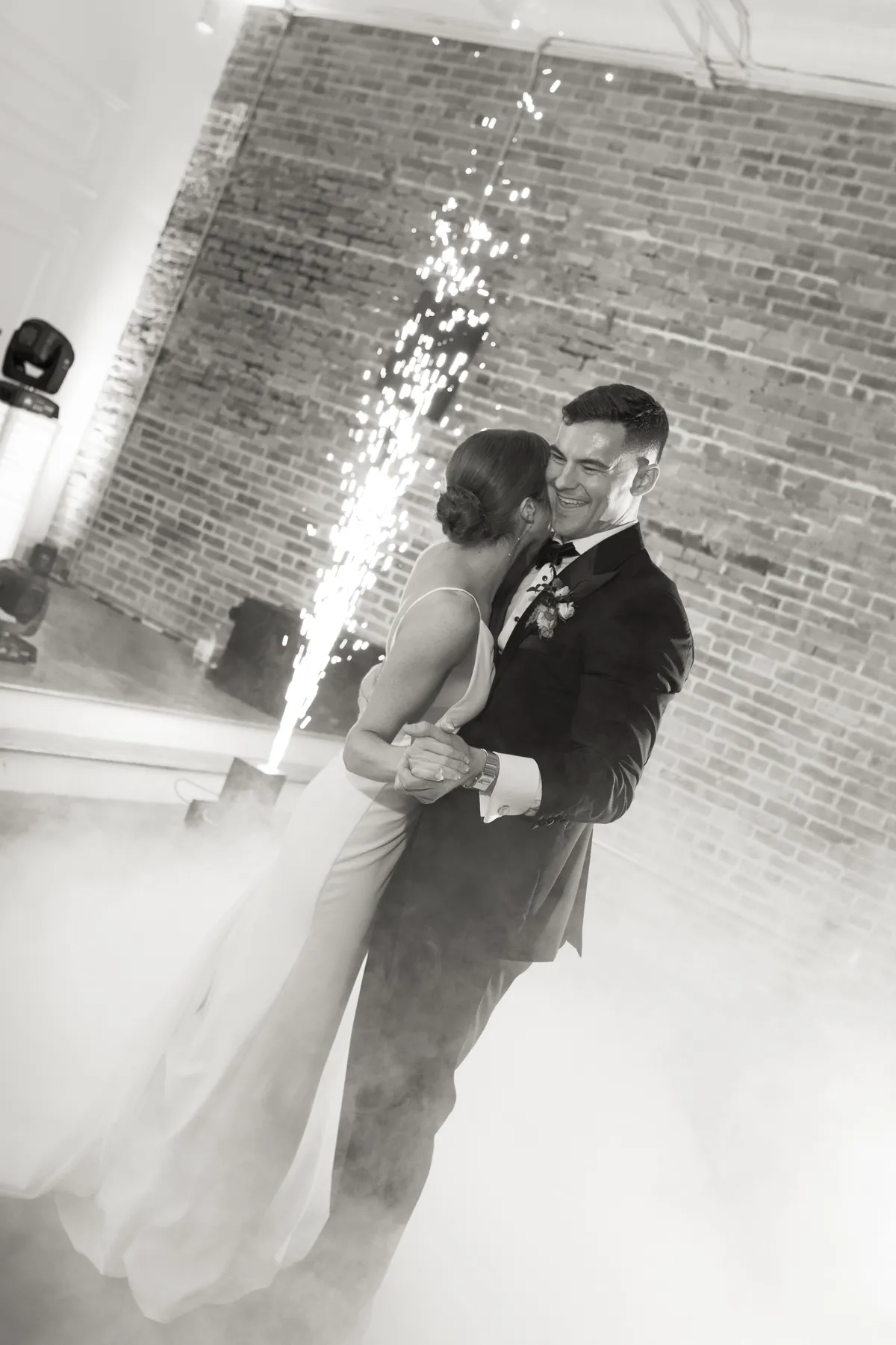 couple-dancing-with-fog-machine-and-sparkles-behind-them