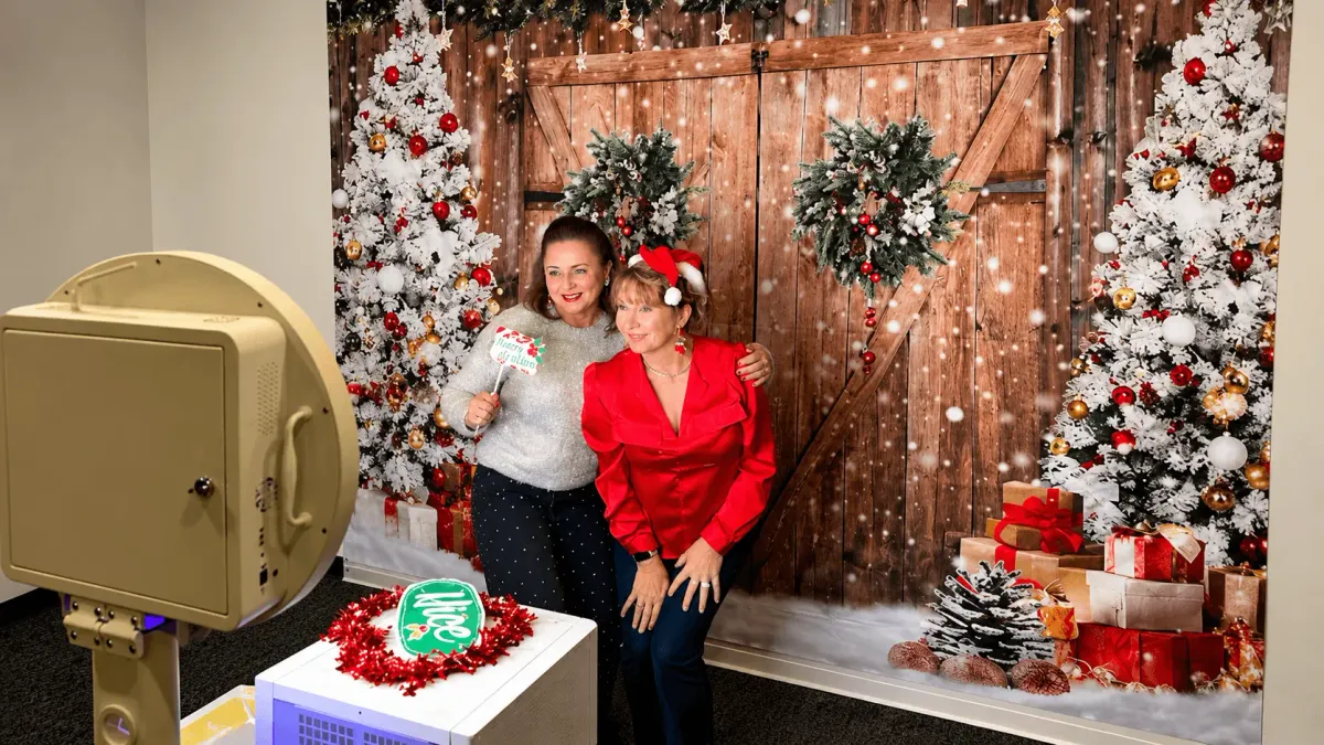 Coworkers posing at a photo booth during a holiday party in Houston