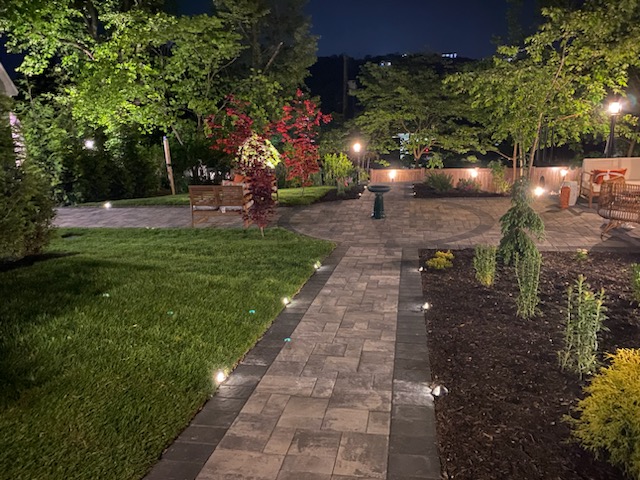 landscape lighting illuminating walkway and garden at night Westchester NY