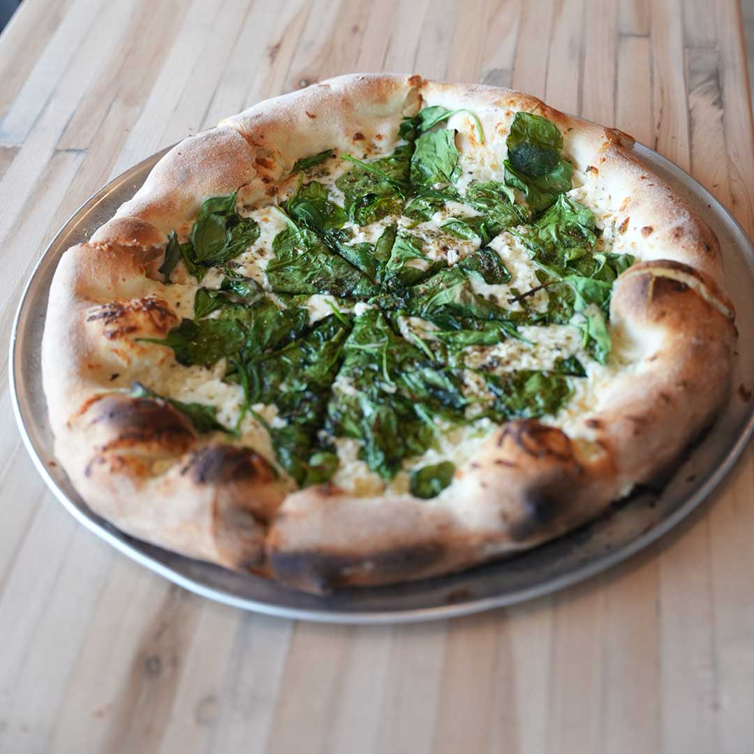 A vibrant vegetarian pizza topped with colorful bell peppers, olives, and onions, styled on a marble countertop, 3:2 aspect ratio.
