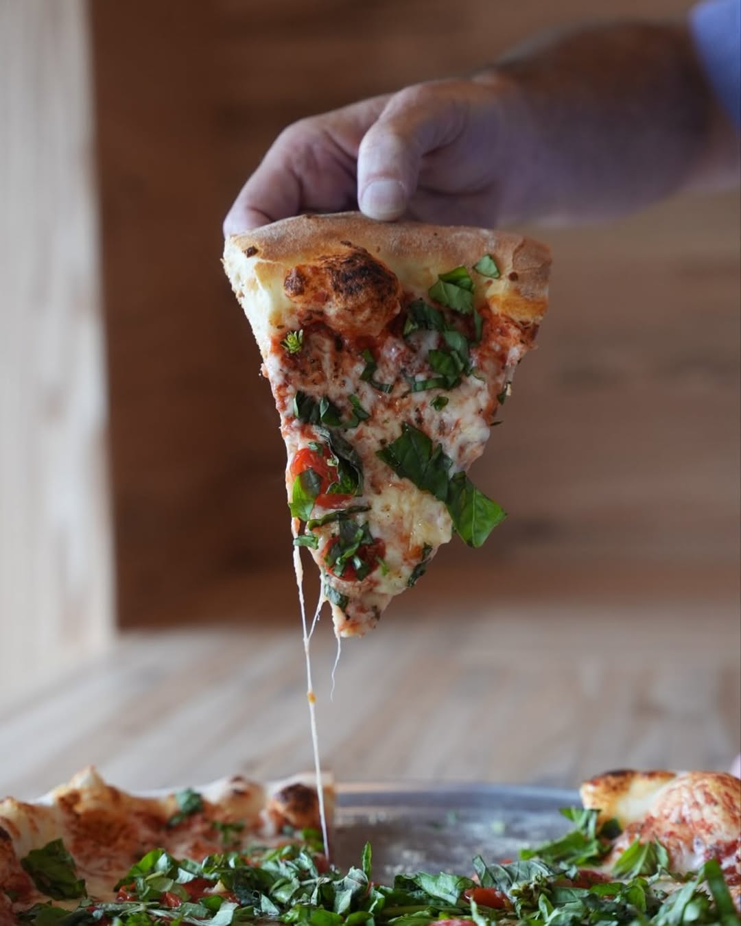 Pizza Roma slice with basil, garlic, and grape tomatoes at Pantaleone’s