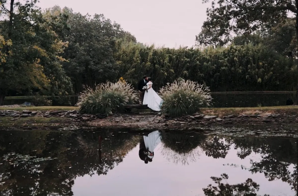 Bride and groom kissing during lakeside  portrait shots after ceremony