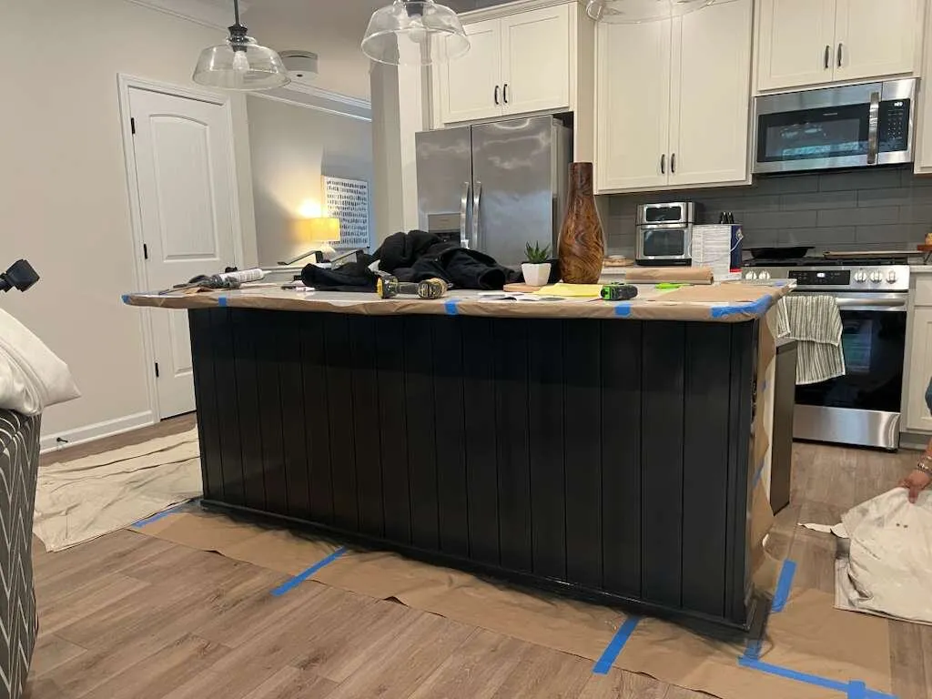 Kitchen island wrapped in dark paneling