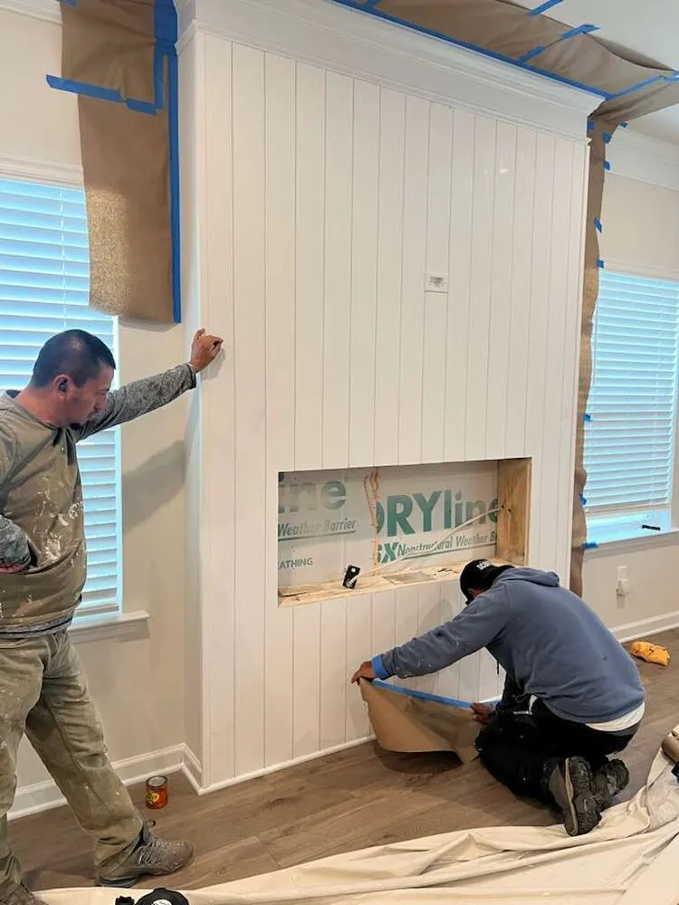 Crew installing shiplap around a fireplace